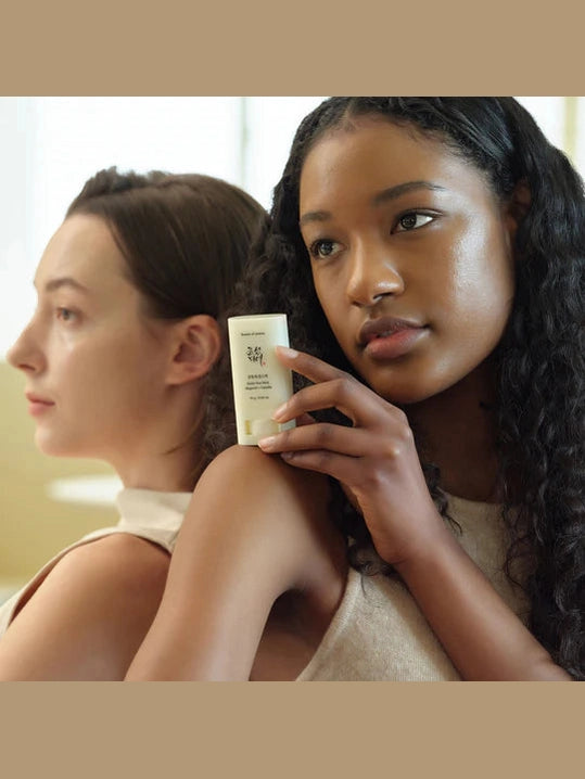 Two women with one holding a skincare product