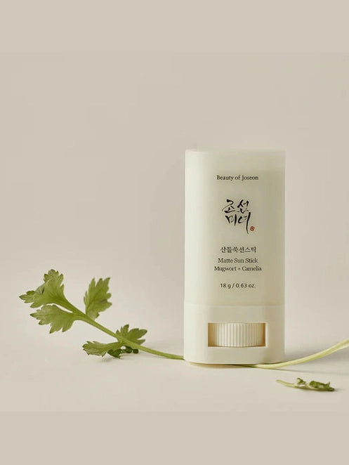 Beauty of Joseon stick with a green leaf on a beige background